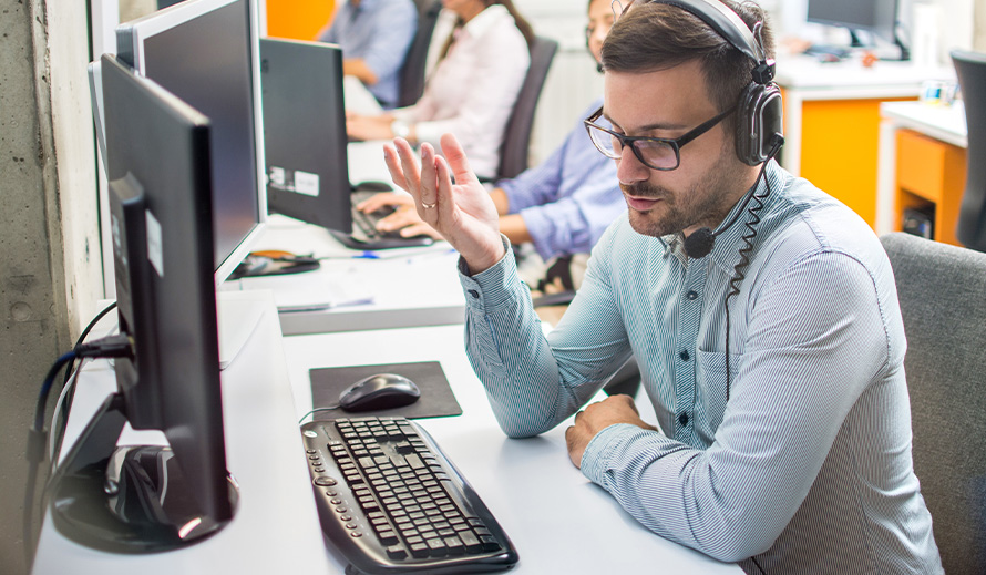 A telephone operator listens intently on a headset. 