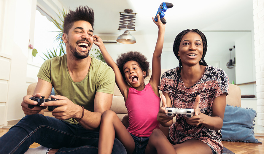 Parents playing video game with their daughter.