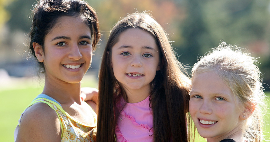 A group of diverse girls smile together. 