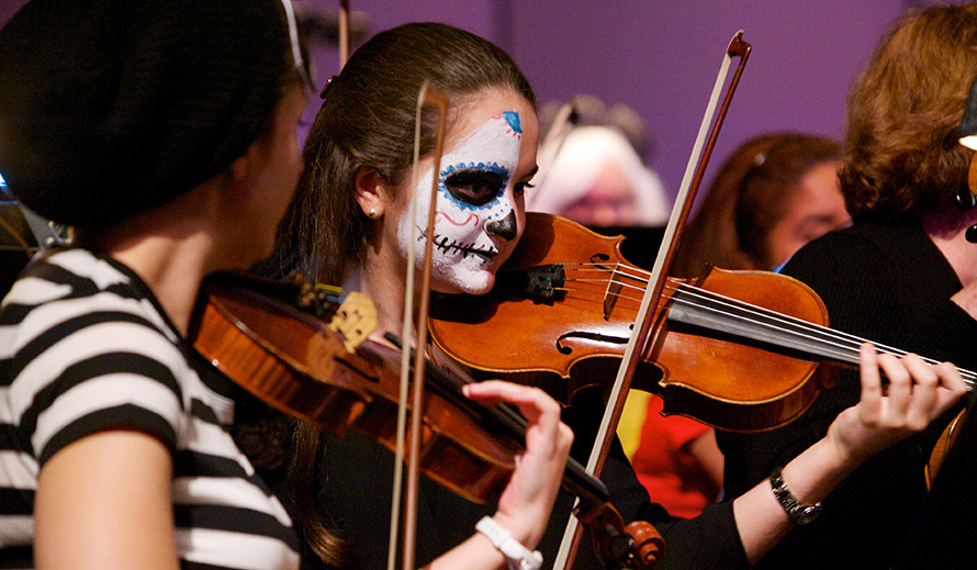 Violinist in mime costume playing her violin