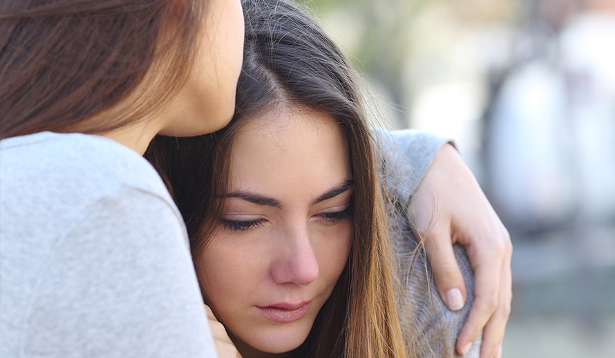 Distraught teen girl being consoled