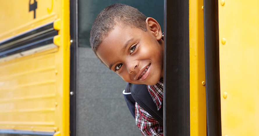 Boy looking back after boarding school bus